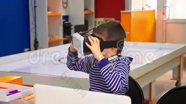 儿童体验虚拟现实。 惊讶的小男孩看着VR眼镜。